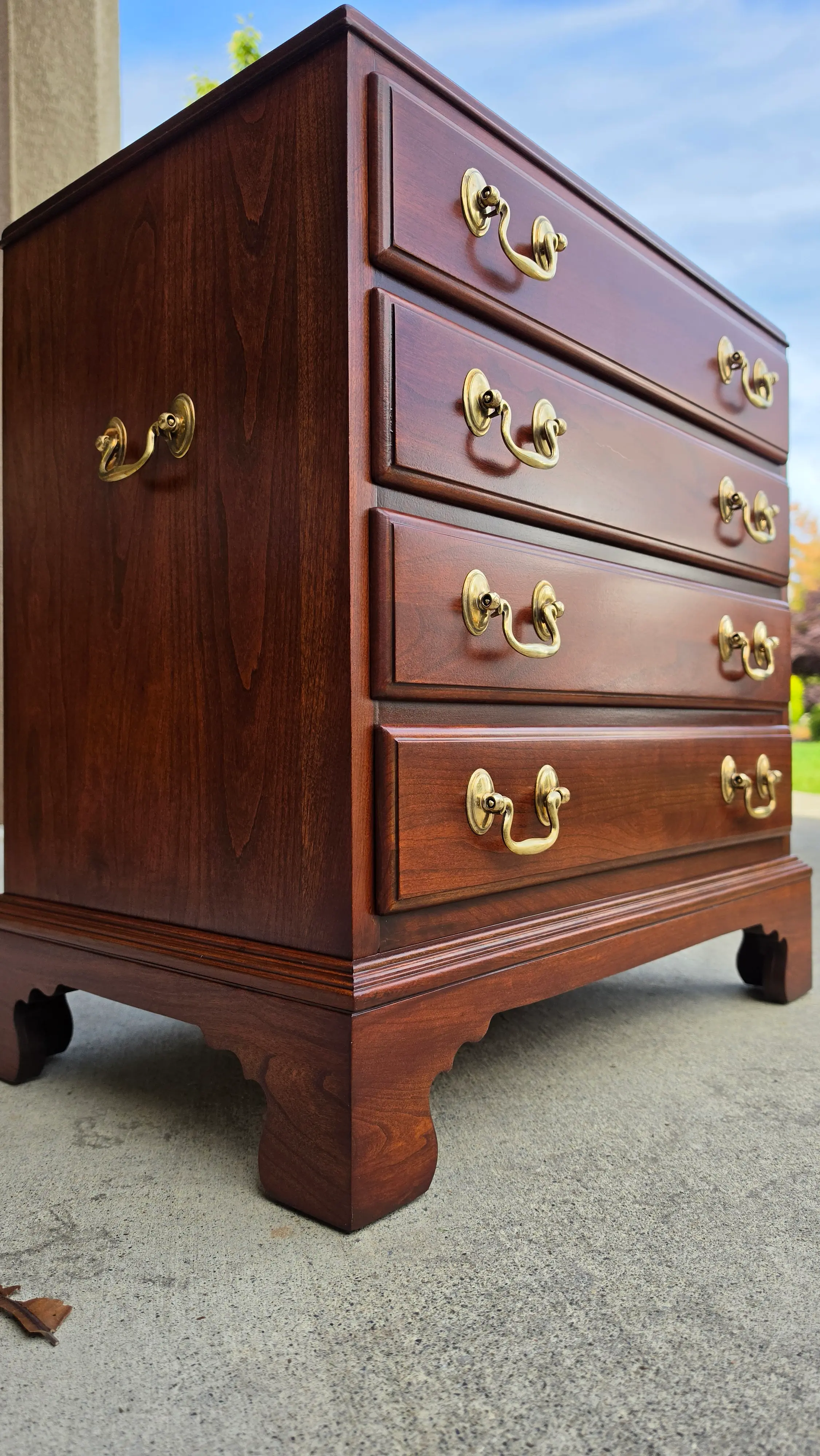 The same Ethan Allen mahogany nightstand after being stripped to bare wood and refinished, with polished brass swan neck pulls
