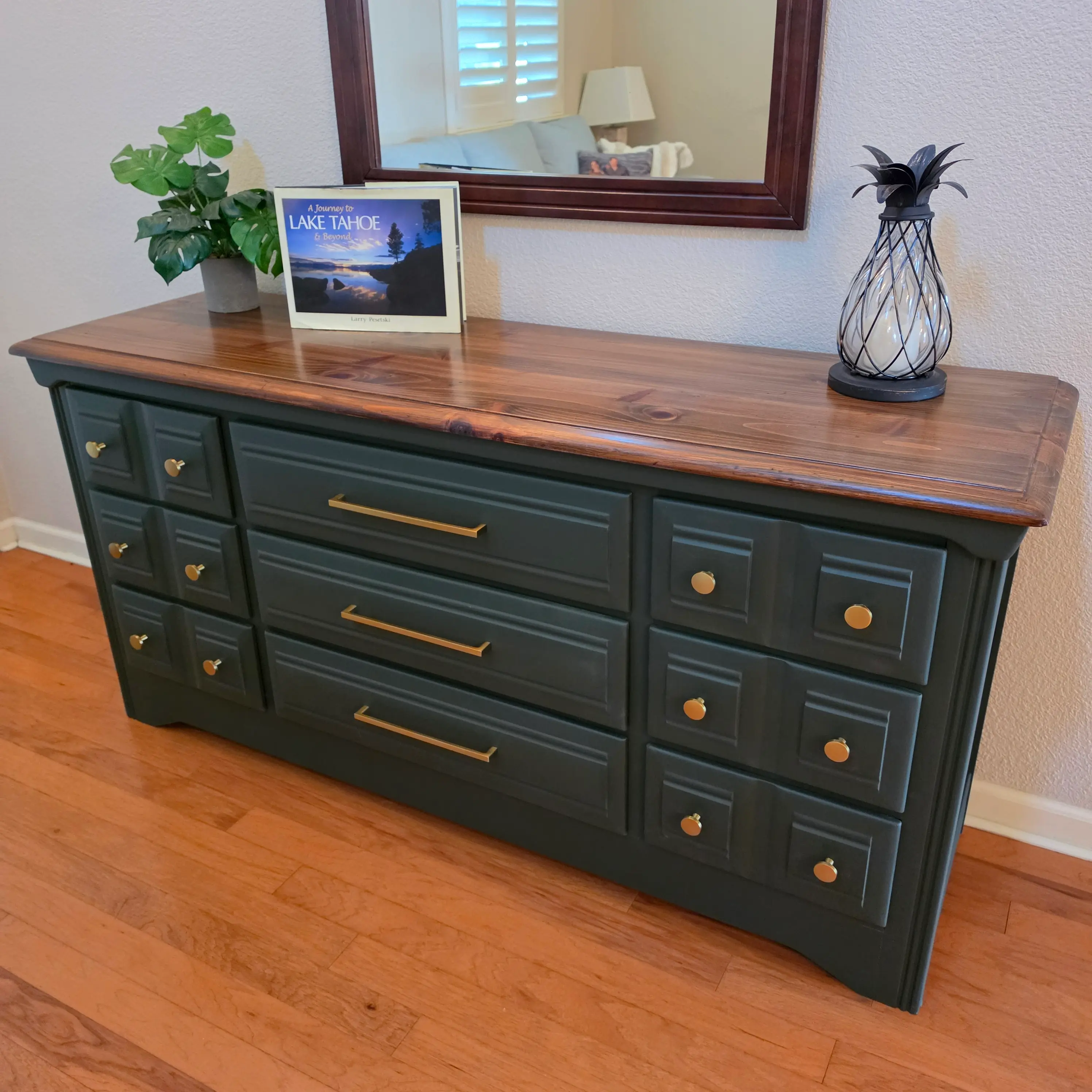 The same pine dresser after refinishing by Furniture Pros, with a natural wood top, deep green painted body and new brass pulls